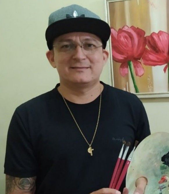 Nilton S., aluno da Art Academy, com paleta e pincéis
