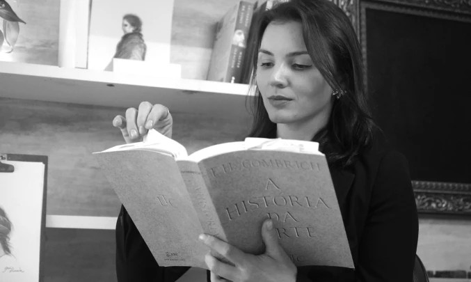 Lari Namaste estudando um livro de História da Arte
